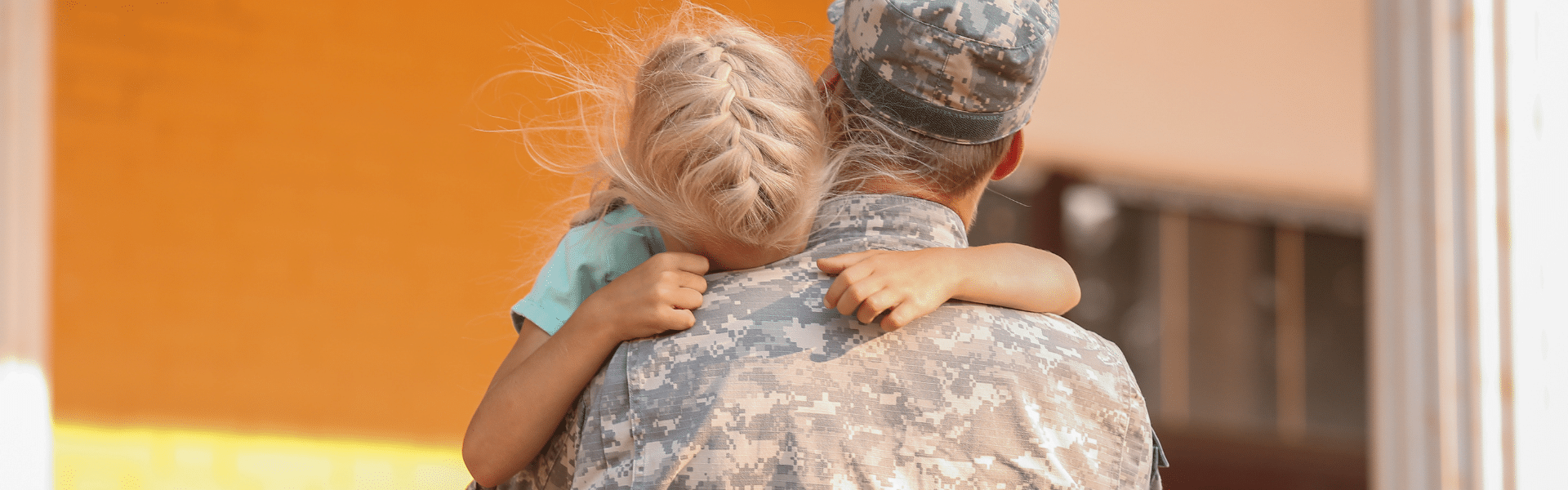 daughter embracing father in military uniform